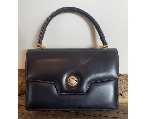 Gucci-A 1960's navy 'Lady Lock' top handle handbag with gold tone hardware and matched purse with red leather lining, interio
