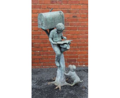 A VERDIGRIS PATINATED CAST METAL GARDEN POST BOX in the form of a boy sitting on a branch reading a book, with a puppy at his