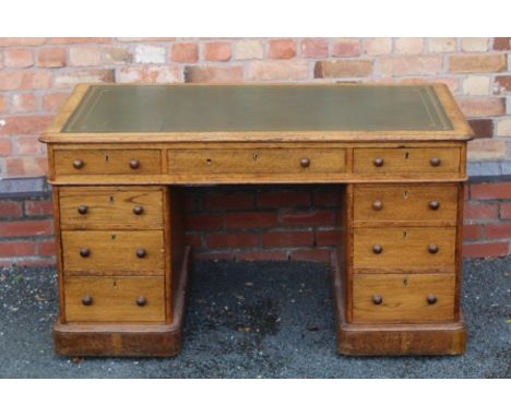 A LATE 19TH CENTURY LIGHT OAK TWIN PEDESTAL WRITING DESK, having skiver insert top, over three drawers supported on two pedes