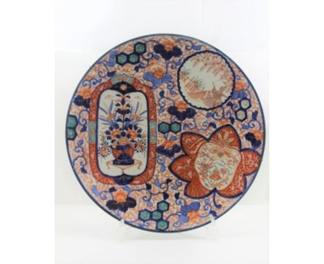 A JAPANESE IMARI POTTERY CHARGER, Meiji period, painted in the typical iron red, cobalt blue and green enamels, overall styli