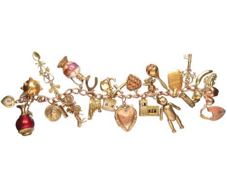 Gold charm bracelet 89.5g total 9ct with 21 charms including a gem-set heart, heart locket, 2 jugs with enamel/glass. 21 key,