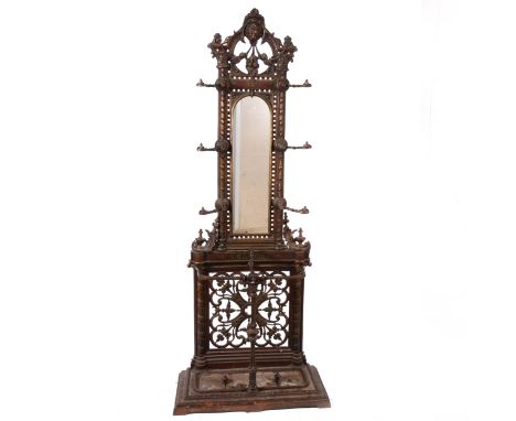 A Victorian cast iron hall stand, casting mark JR, registration mark for 1856, arched mirror back, under a lion mask cresting