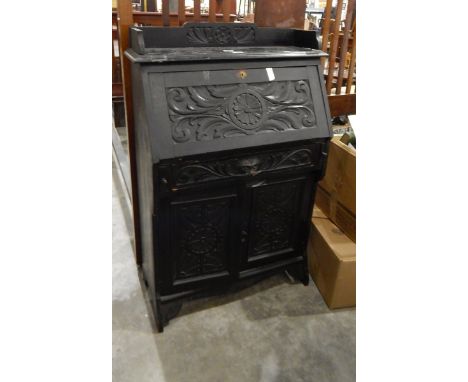 Victorian ebonised and carved bureau, with open shelf top, the fall enclosing pigeonholes, frieze drawer and a pair of cupboa