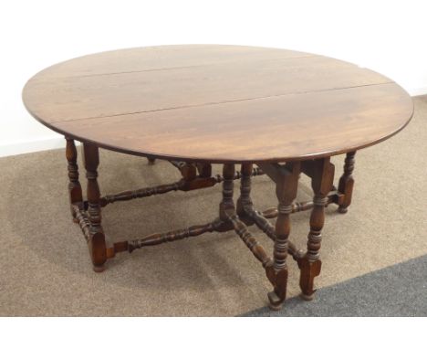 Large 17th century style oak dining table, oval drop leaf top, double gate action base, turned supports jointed by stretchers