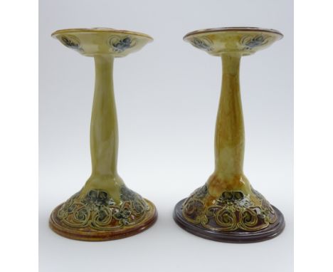 Pair of Royal Doulton candlesticks, the domed bases with a raised stylised leaf design on a shaded beige ground with incised 