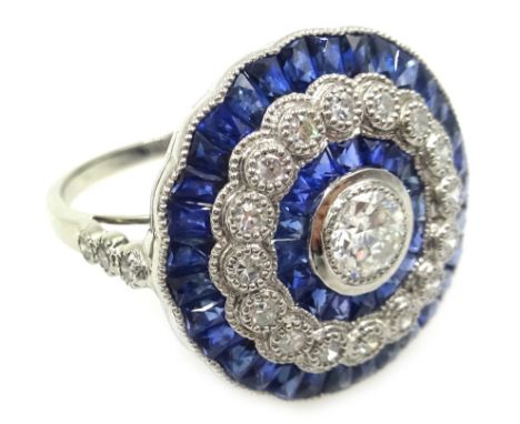 Sapphire and diamond circular platinum (tested) ring, the central diamond surrounded by calibre cut sapphires, halo of diamon