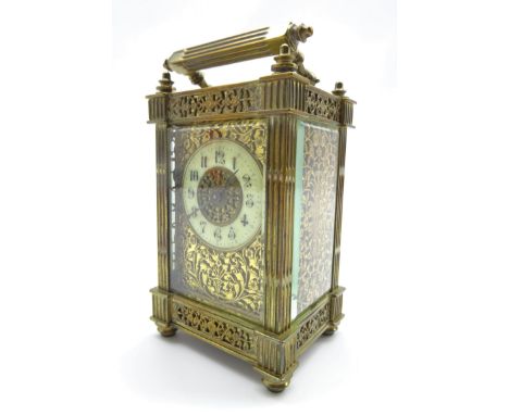 Late 19th century brass carriage clock, circular Roman enamel dial, pierced floral scrolling brass panels with engraved flowe