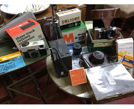 A Collection of various cameras which includes makes such as zenith & minolta, Together with Chrome Velbon deluxe tripod. 