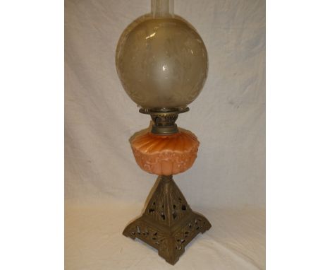 A Victorian cast iron and brass oil lamp with orange opaque glass reservoir and etched glass circular shade