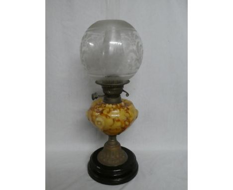 A Victorian brass oil lamp with marbled glass reservoir and etched glass shade on ceramic base