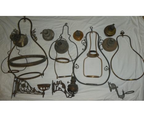 A selection of Victorian and later brass hanging oil lamp holders, three wall-mounted lamp brackets, lamps etc (af)