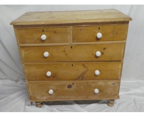 An old pine chest of two short and three long drawers with ceramic handles on turned feet