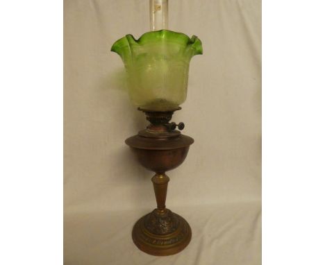 An Edwardian copper and brass oil lamp with raised decoration and green-tinted glass floral etched shade (shade in good condi