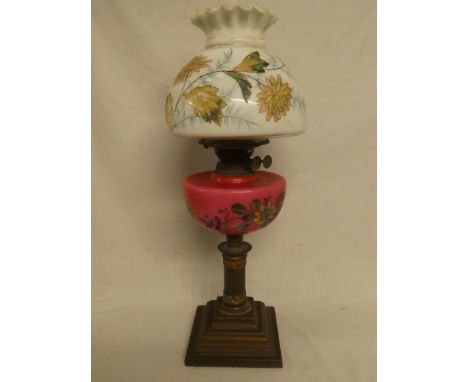A Victorian brass and copper mounted oil lamp with pink floral ceramic reservoir and opaque glass floral shade (shade in good