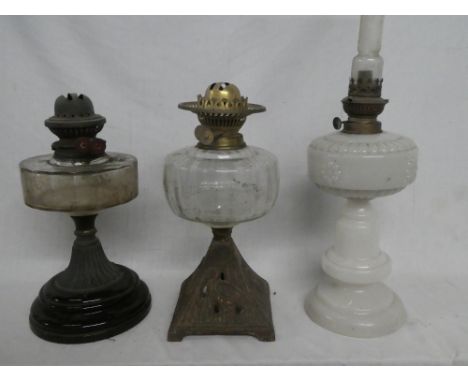 An Edwardian opaque glass oil lamp with brass mounts and two Victorian oil lamps with clear glass reservoirs (3)