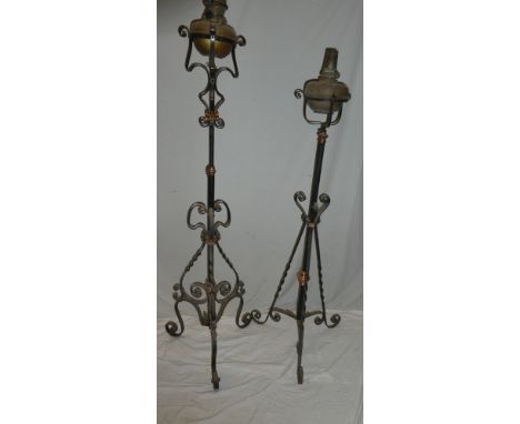 Two wrought iron and copper mounted adjustable oil lamp standards with scroll decoration supporting  brass oil lamps