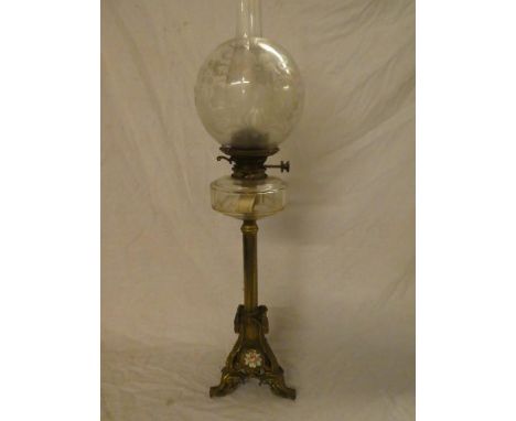 An old ornate brass oil lamp with porcelain mounted trefoil base, clear glass reservoir and etched glass shade (shade with ti