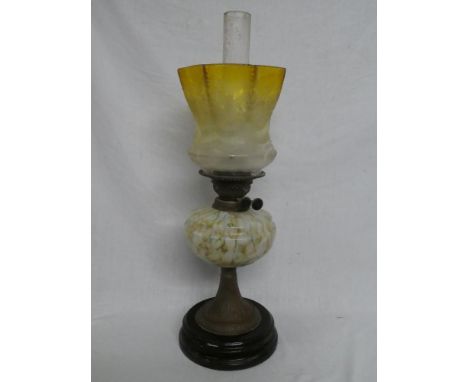 A Victorian brass oil lamp with marbled glass reservoir and yellow-tinted etched glass shade (tiny edge chips to shade)