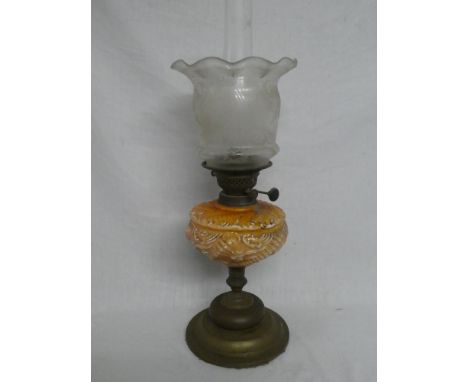 An Edwardian brass oil lamp with orange-tinted glass reservoir and etched glass shade (shade in good condition)