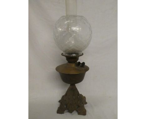 A Victorian cast iron and brass mounted oil lamp with clear glass shade
