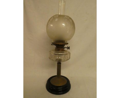 An Edwardian brass oil lamp with clear glass reservoir and etched glass shade on ceramic base