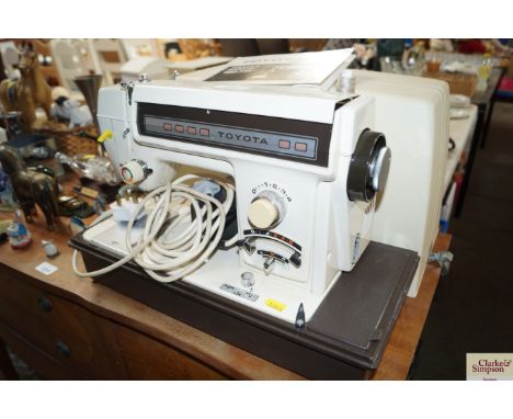A Toyota sewing machine in fitted case together with an owners manual 