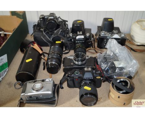 A quantity of various cameras and lenses to include Nikon, Zenith, Pentax