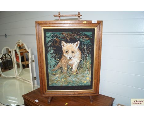 An oak fire screen with embroidered panel depicting a fox
