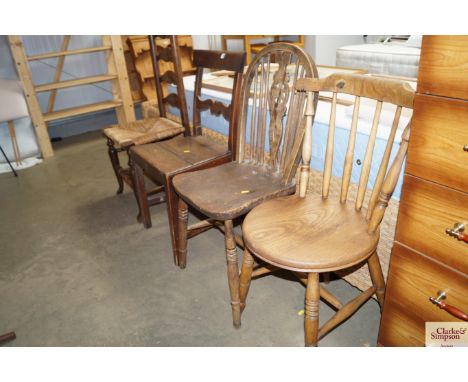 An antique bar back oak chair together with a mahogany ladder back and rush seated chair; an elm seated stick and wheel back 