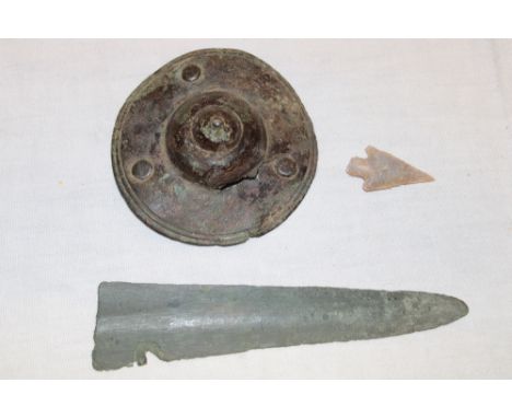 The tip of a Bronze Age sword 4½" long; an ancient bronze shield boss and a flint arrowhead (3)