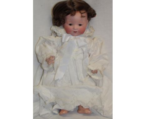 A porcelain headed Dream Baby doll by Armand Marseille marked "A.M. Germany 351/4K" with composition jointed body 17" long