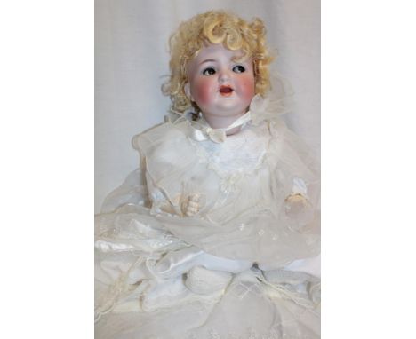 A German porcelain headed doll marked "K R Symon & Halbig Germany 126" with composition jointed body 19" long