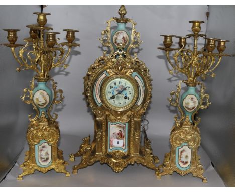 A Louis XV style 3 piece clock set flanked by 5-light candelabra