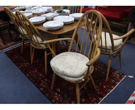 An Ercol light elm dining table and six spindle back dining chairs (4+2), 153cm wide