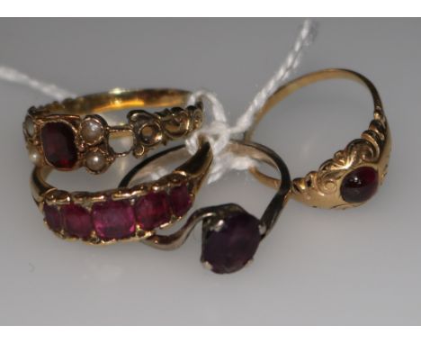 A ruby half-hoop ring in yellow metal setting and three other assorted rings.