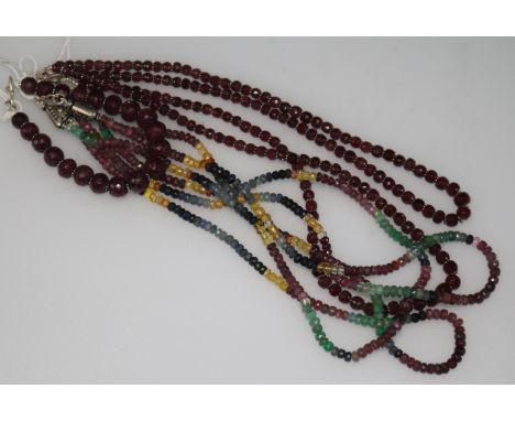 An Indian double strand facetted ruby bead necklace, a similar bracelet and a multi gem set triple strand necklace.