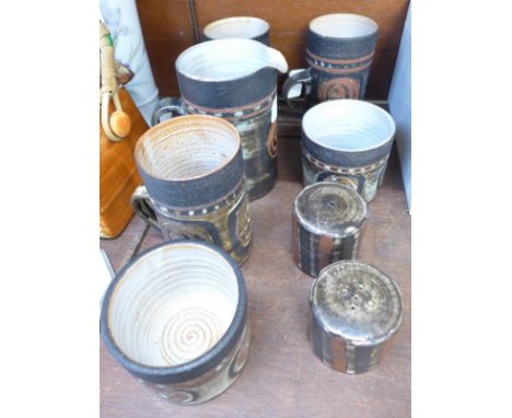 A collection of Briglin pottery; salt, pepper, three mugs, two pots and a jug