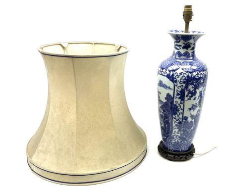 A Chinese blue and white table lamp, of slender baluster form decorated with alternate panels of landscapes and phoenix among