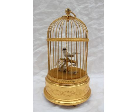A Sainte-Croix Reuge music automaton of a singing bird on a perch in a domed gilded cage, with ring handle, 29cm high copy li