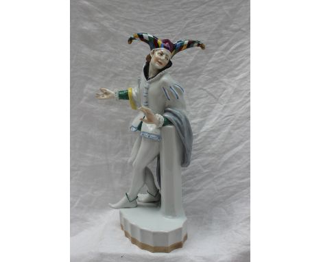 A Karl Ens porcelain figure of a Jester, with multicoloured tricorn hat leaning against a pillar, blue underglaze mark, 34.5c