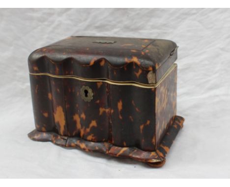 A George III tortoiseshell tea caddy, of rectangular form with a serpentine front on flattened bun feet, the interior fitted 