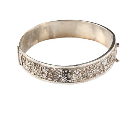 A Chinese silver hinged bangle, with chased and relief embossed Buddha and chrysanthemum decoration, band width 14.6mm, inter