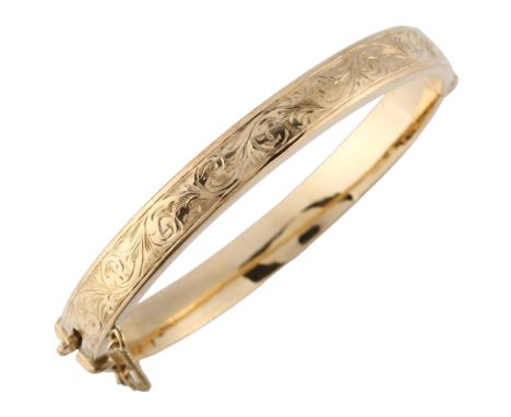 A late 20th century 9ct gold hinged bangle, with engraved foliated decoration, maker's marks S and P, hallmarks Birmingham 19