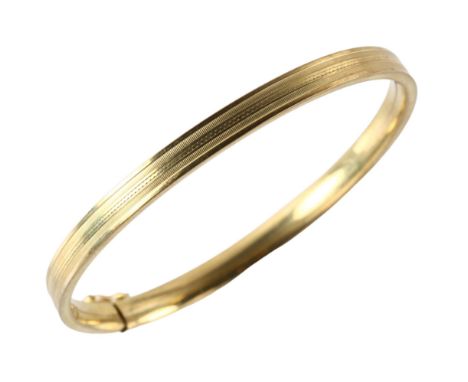 A Continental 8ct gold hinged bangle, engine turned decoration, band width 5.1mm, internal circumference 18cm, 9gNo damage or