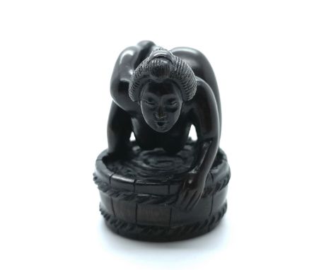 A signed carved wooden Japanese netsuke a study of a naked lady washing while being watched by a frog