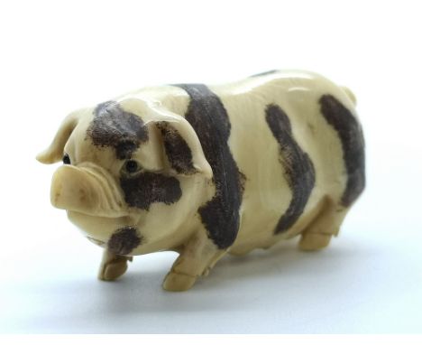 A signed carved ivory Japanese netsuke of a pregnant sow