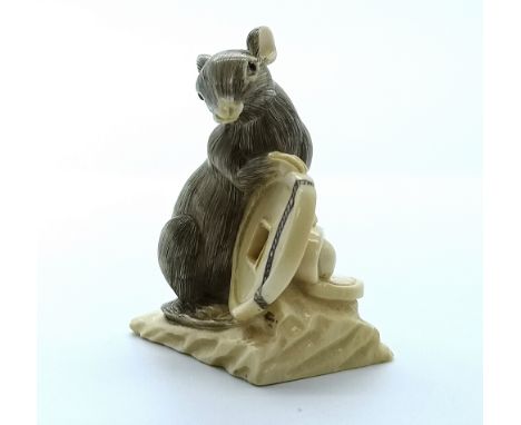 A signed carved ivory Japanese netsuke of a rat holding a coin