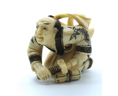A signed carved ivory Japanese netsuke of aa kneeling Samurai about to draw his sword