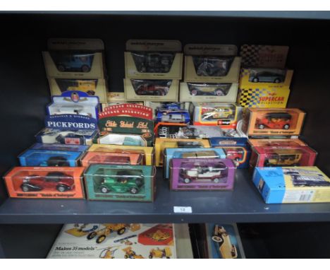 A shelf of mixed diecasts including Matchbox Models of Yesteryear, Corgi Classics, Burago  and similar, all boxed