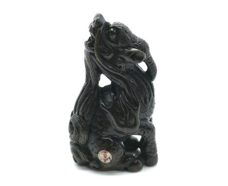 A carved and signed fruitwood Japanese netsuke of a dragon